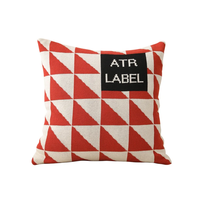 Geometrisches Strickkissen mit Dreiecksmuster und Logo-Patch
