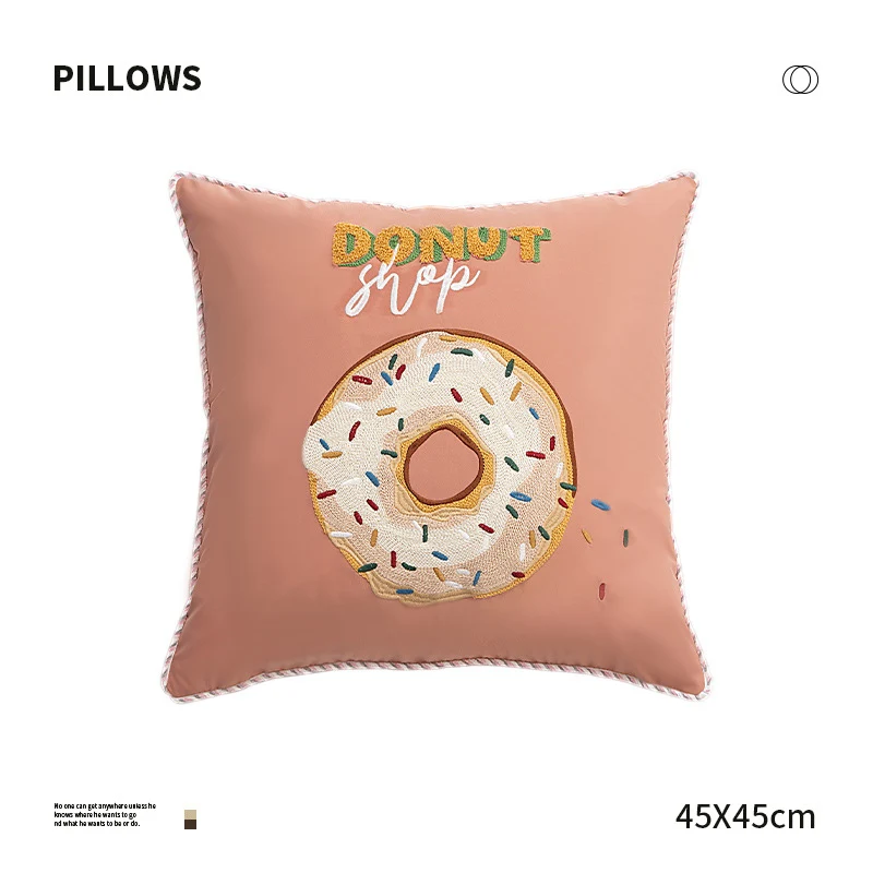 Quadratisches Dekokissen mit gesticktem Donut-Motiv und dekorativer Kederkante