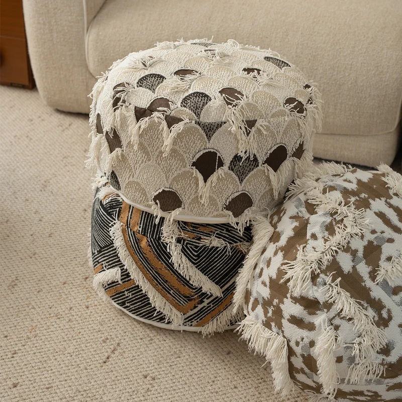 Runder gewebter Sitzpouf mit Boho‑Quasten und strukturierter Tuftoberfläche