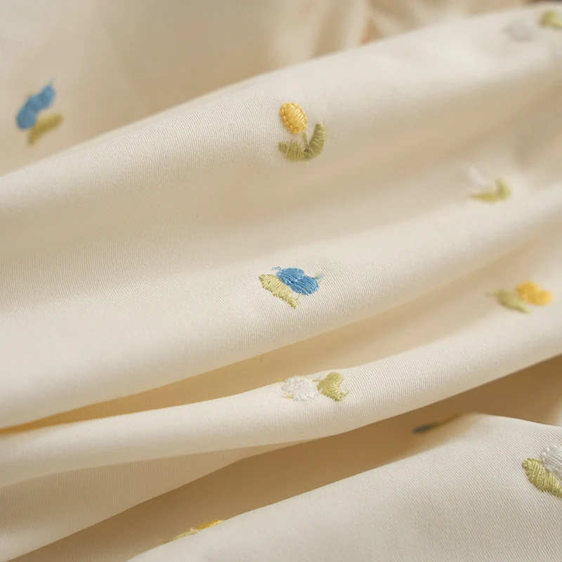 Dekoratives Kissen mit Rüschen und gesticktem Blumenmuster