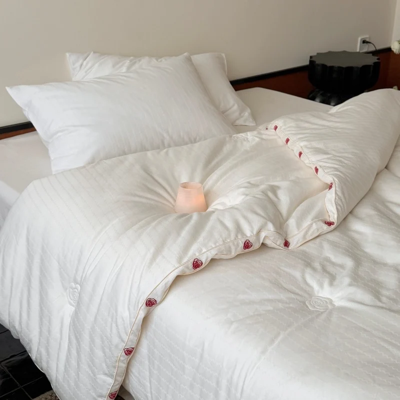 Steppbett aus Baumwollsatin mit gestickter Rosenborte