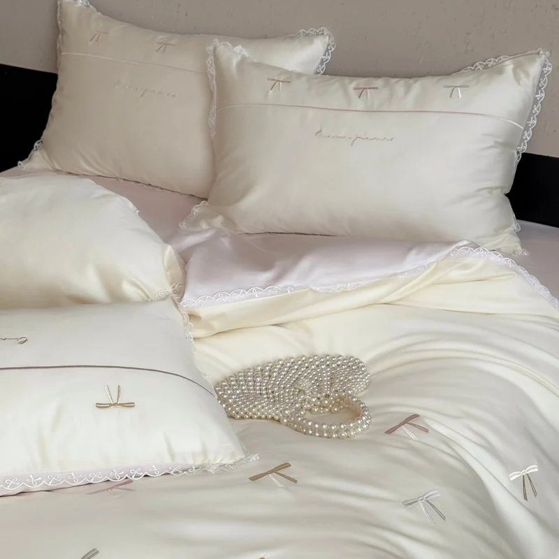 Elegante Bettwäschegarnitur aus seidig-feinem Satin mit bestickten Schleifen und Spitzenbordüre
