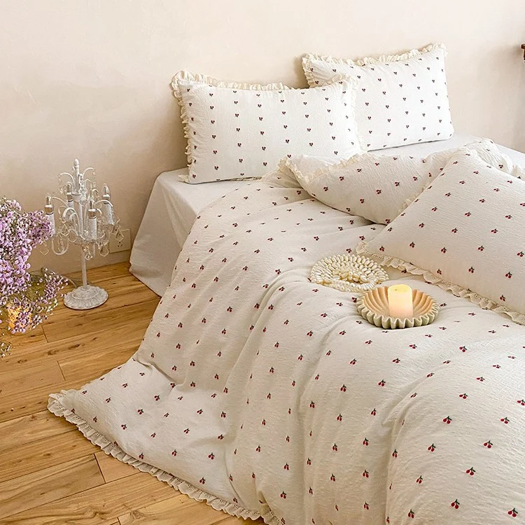 Gestepptes Bettwäscheset aus Baumwoll‑Musselin mit zartem Kirschenprint und Rüschenkante