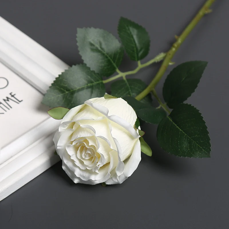 Realistische Seidenrose mit Grünanlagen