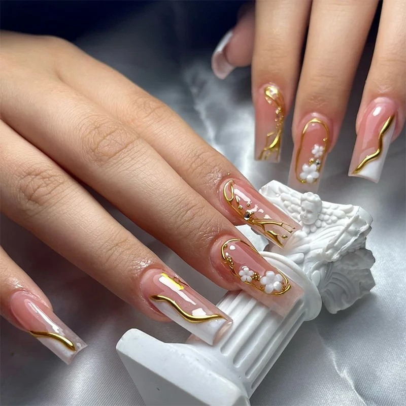 Kunstnagelset mit elegantem Goldakzent und floralen Designs Karnz