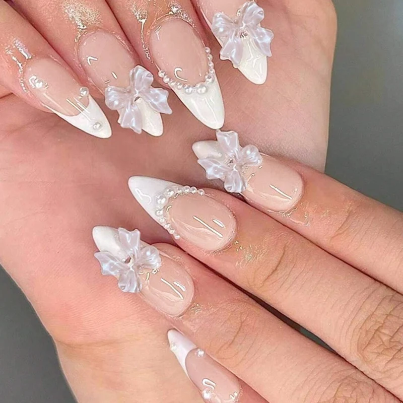 Kreatives Kunstnagelset mit eleganten Schleifen und Perlenelementen Karnz