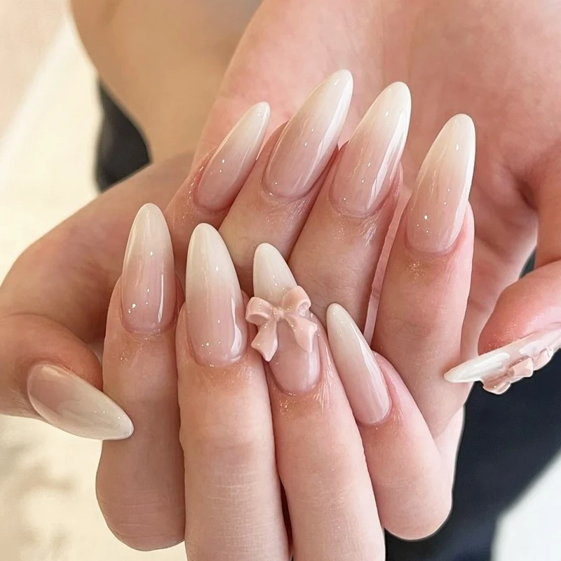 Elegantes Kunstnagelset mit luxuriösem Ombre-Effekt und zarten Schleifenakzenten Karnz