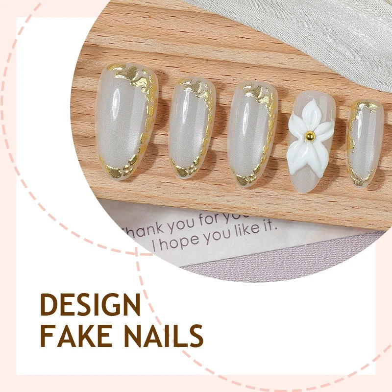 Elegantes Kunstnagelset mit Goldakzenten und Blütenmuster Karnz