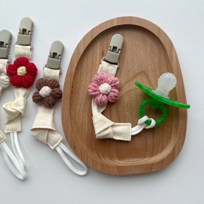 Handgemachter Baumwoll-Schnullerclip mit Gingham-Gurt und gestrickter Blume