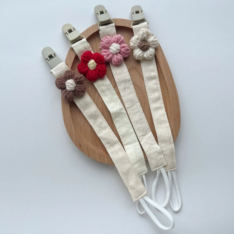 Handgemachter Baumwoll-Schnullerclip mit Gingham-Gurt und gestrickter Blume
