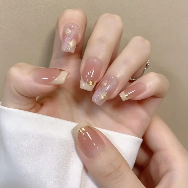 Elegante französische Nagelverlängerungen mit goldenen Akzenten