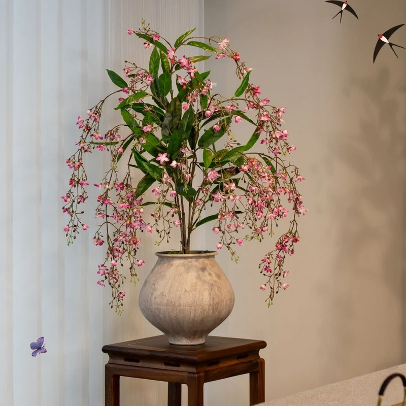 Lebensechte künstliche Blumenarrangement in dekorativem Topf