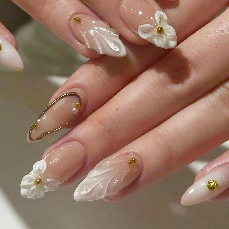 Kunstnagelset mit floralen 3D-Designs und eleganten goldenen Akzenten Karnz