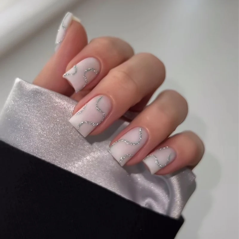 Künstliches Nagelset mit eleganten Linien und Glitzerakzenten Karnz