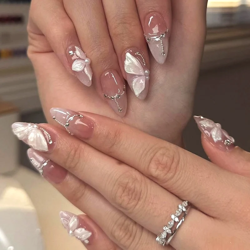 Künstliche Nägel mit zarten Schmetterlings-Design und Glitzerakzenten Karnz