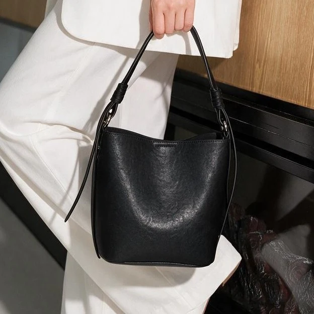 Strukturierte Leder-Schulter-Bucket-Tasche mit geknotetem Träger